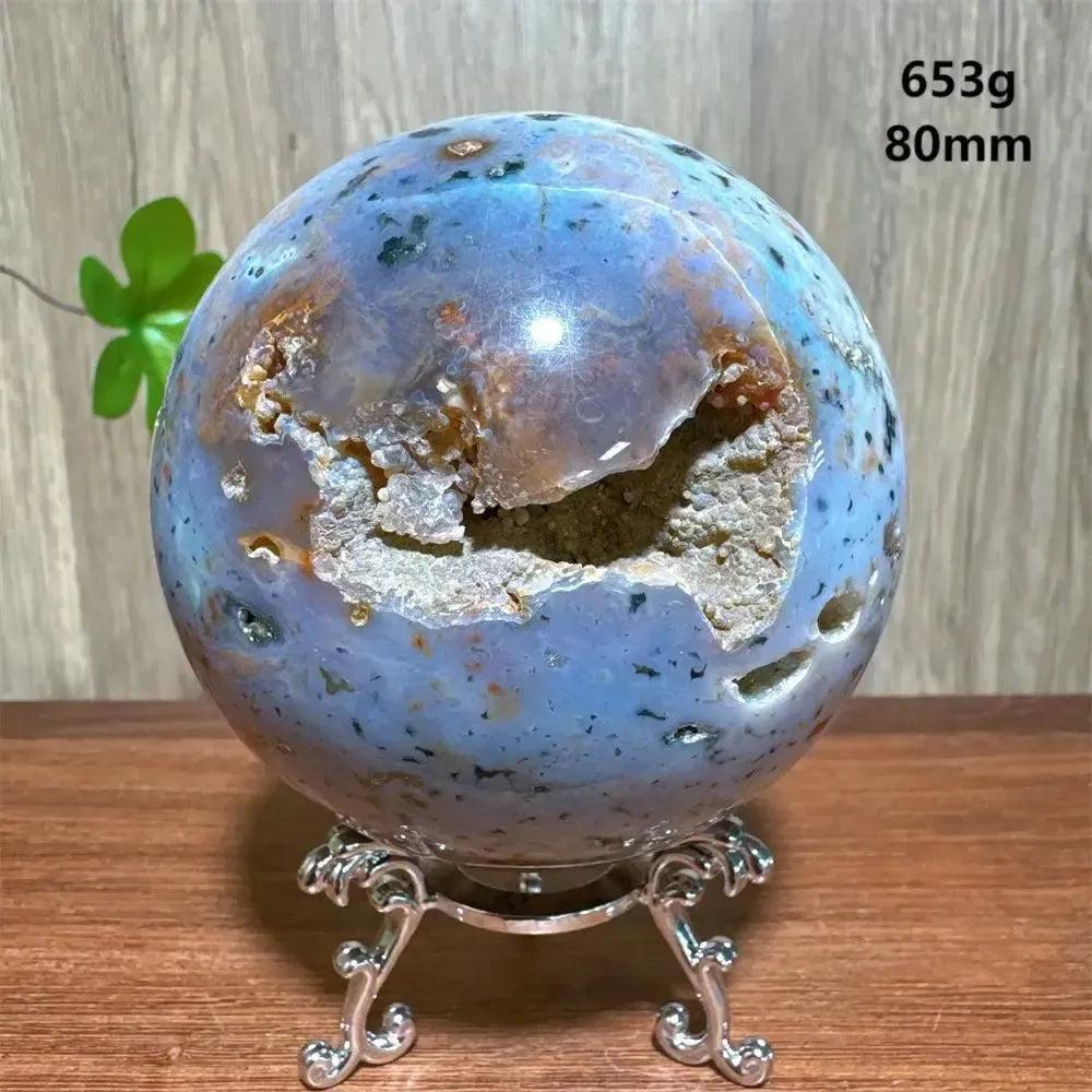 Ocean Jasper sphere, 80mm, 653g, with blue, orange, and white orbicular patterns, on a silver stand from Crystal Destiny.
