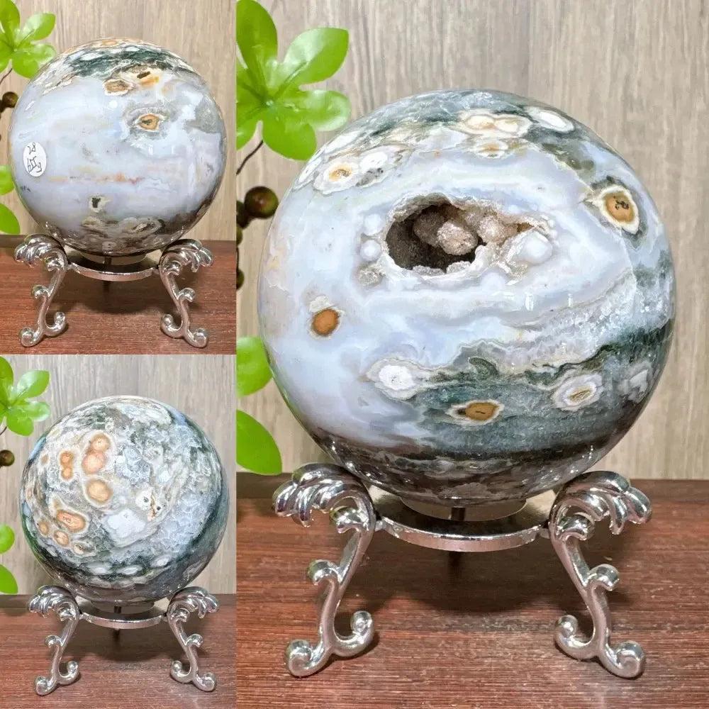 Ocean Jasper sphere from Crystal Destiny, featuring unique green, white, and brown orbicular patterns with a geode opening.