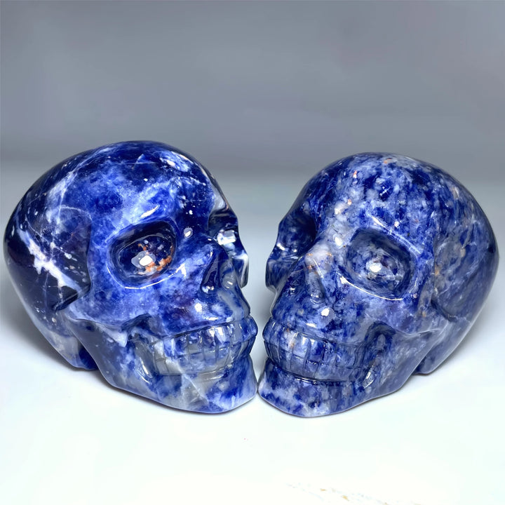 Two large, polished sodalite crystal skulls with deep blue hues, perfect for home decor and calming energy.