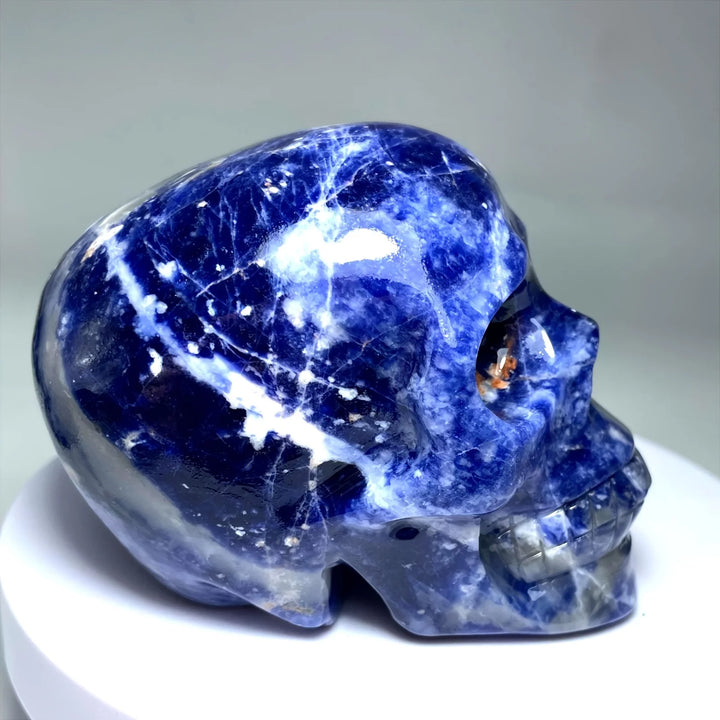 Large polished Sodalite crystal skull with deep blue hues and white veining, perfect for home decor and healing energy.