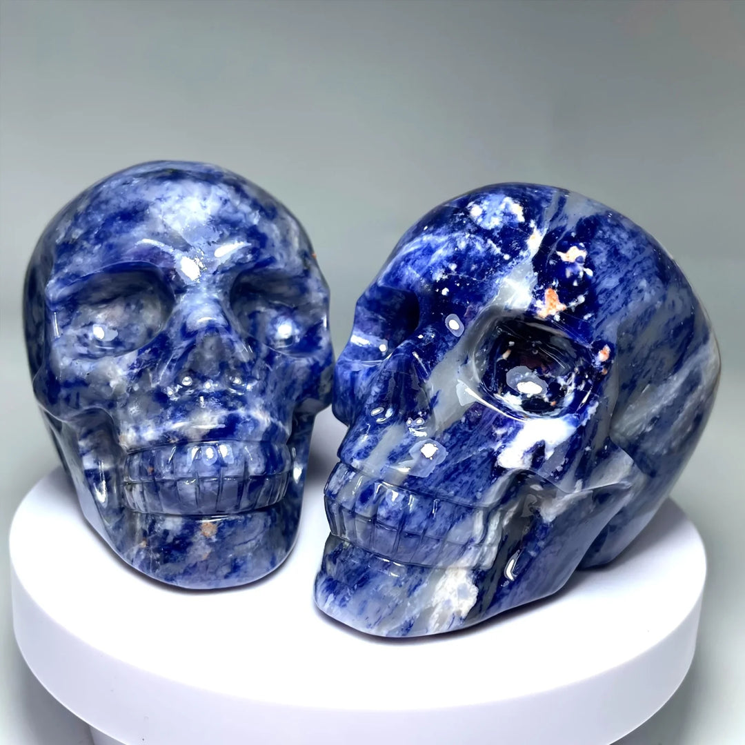 Two large, polished sodalite crystal skulls with deep blue and white marbling, perfect for healing decor and unique gifts.