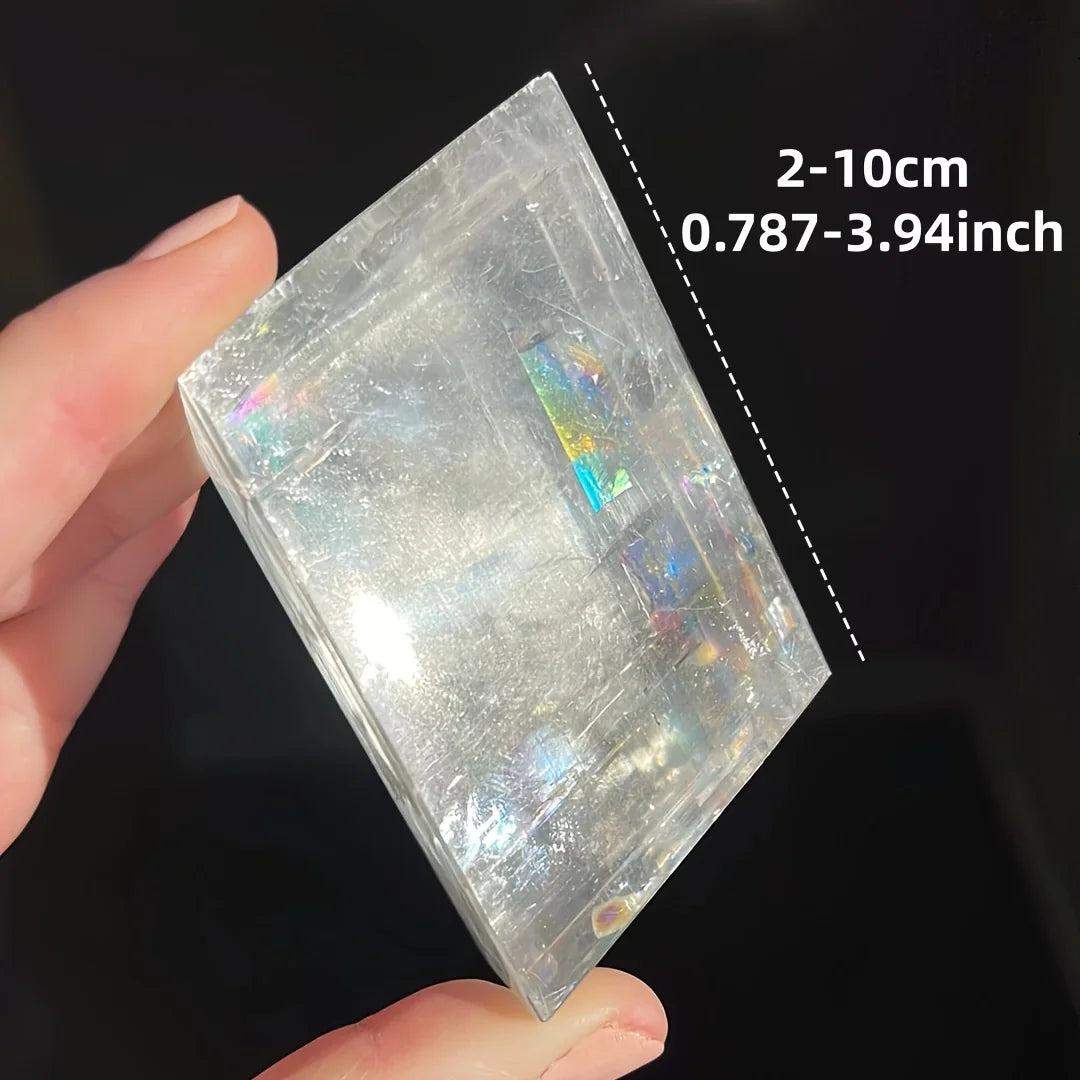Clear Brazilian optical calcite cube with iridescent flashes, held in hand, showing 2-10cm size.