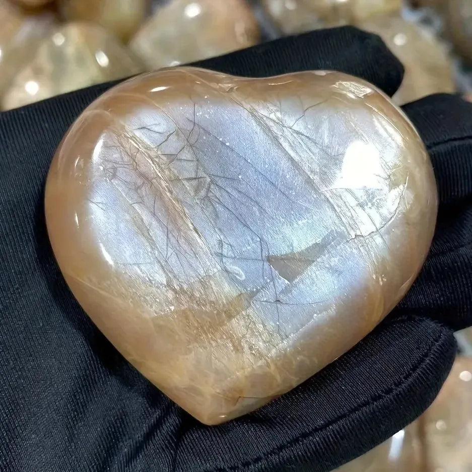 Hand-carved Orange Moonstone heart from Crystal Destiny, showing warm peachy-orange tones and iridescent shimmer.