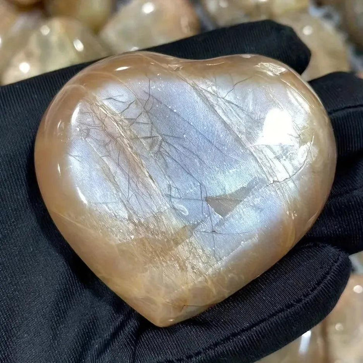 Hand-carved Orange Moonstone heart from Crystal Destiny, showing warm peachy-orange tones and iridescent shimmer.