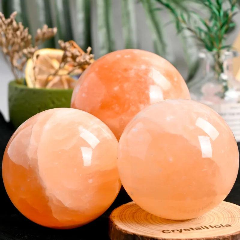 Three polished Orange Selenite crystal spheres with warm, translucent peach tones for healing and radiant energy.