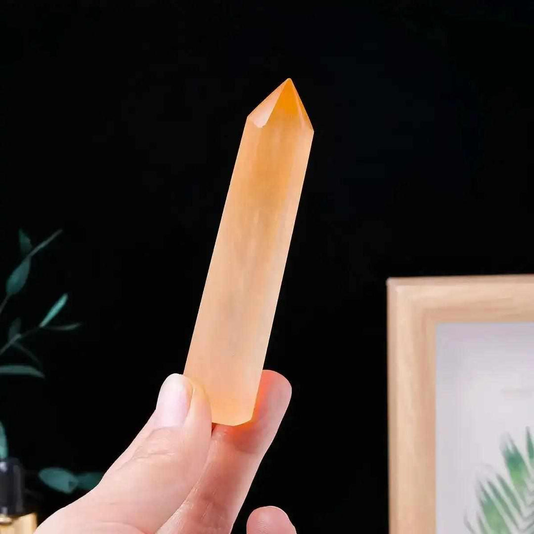 Polished orange selenite tower with silky fibers, perfect for sacral chakra healing and adding a warm glow to your space.