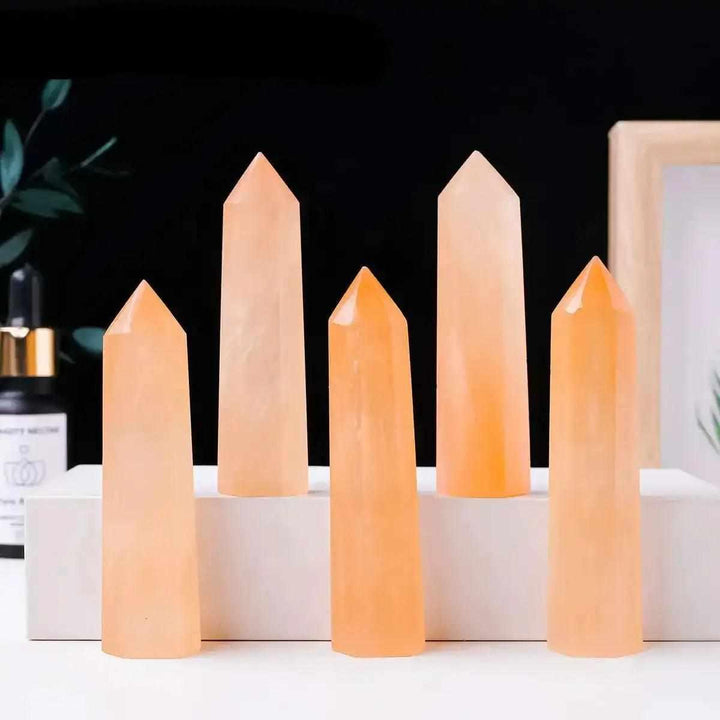 Polished orange selenite tower point with silky fibers, perfect for sacral chakra healing and warm, creative energy.