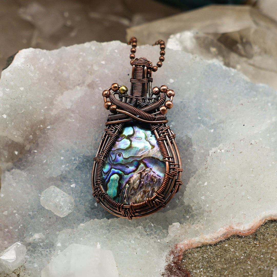 Iridescent Paua Shell Wire Wrap Pendant, handcrafted in healing copper, offering emotional balance and intuition.