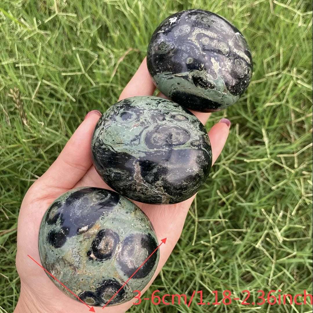 Polished green and black Peacock Eye Crystal Palm Stones for grounding and protection.