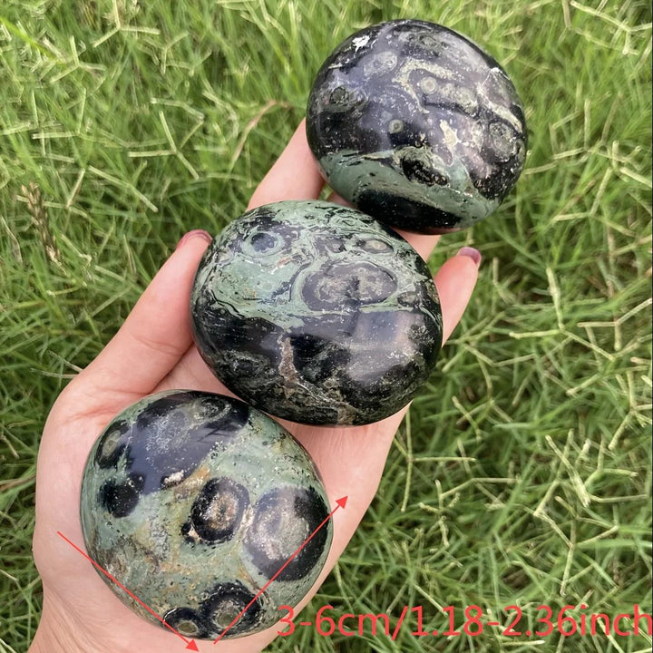 Polished green and black Peacock Eye Crystal Palm Stones for grounding and protection.