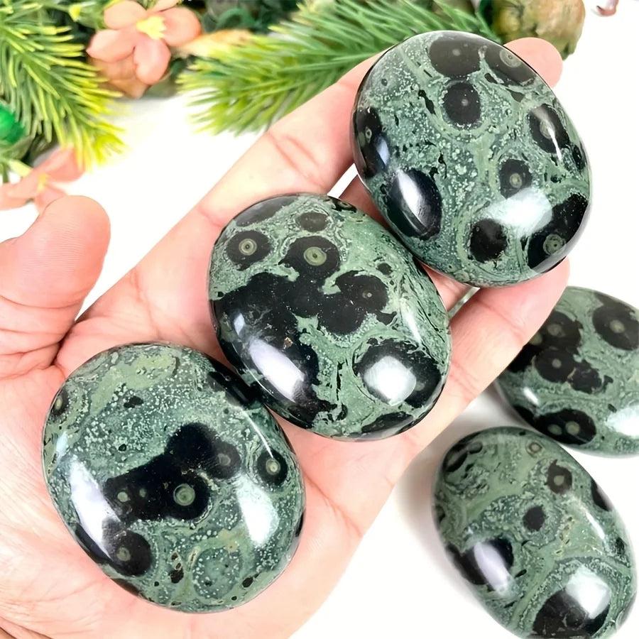 Polished green and black Peacock Eye crystal palm stones for grounding and protection.