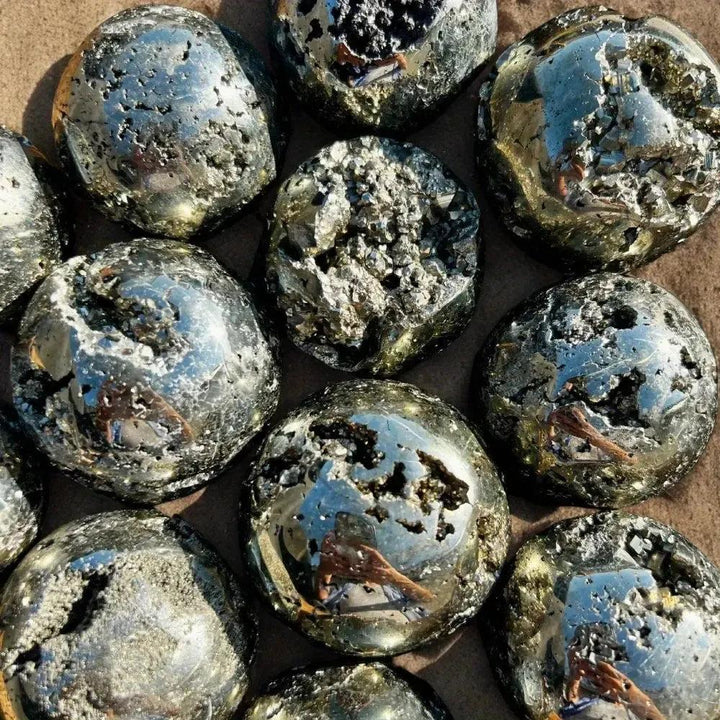 Peruvian Pyrite Crystal Ball: Polished metallic gold spheres with natural cubic crystal inclusions, radiating abundance.