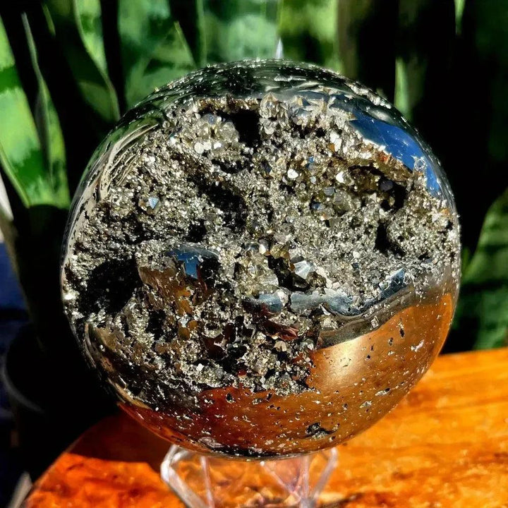 Peruvian Pyrite Crystal Ball: Polished metallic gold sphere with a dazzling raw cubic crystal geode.