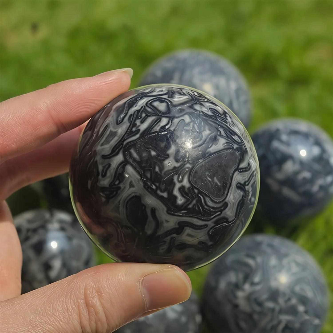Polished Picasso Jasper sphere featuring abstract black, gray, and cream lines for grounded creativity and meditation.
