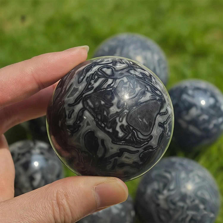 Polished Picasso Jasper sphere featuring abstract black, gray, and cream lines for grounded creativity and meditation.