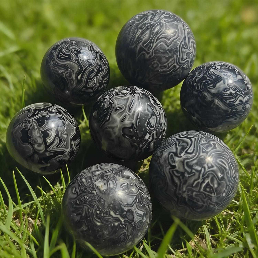 Polished Picasso Jasper spheres featuring abstract black, gray, and cream lines for grounded creativity and inspiration.