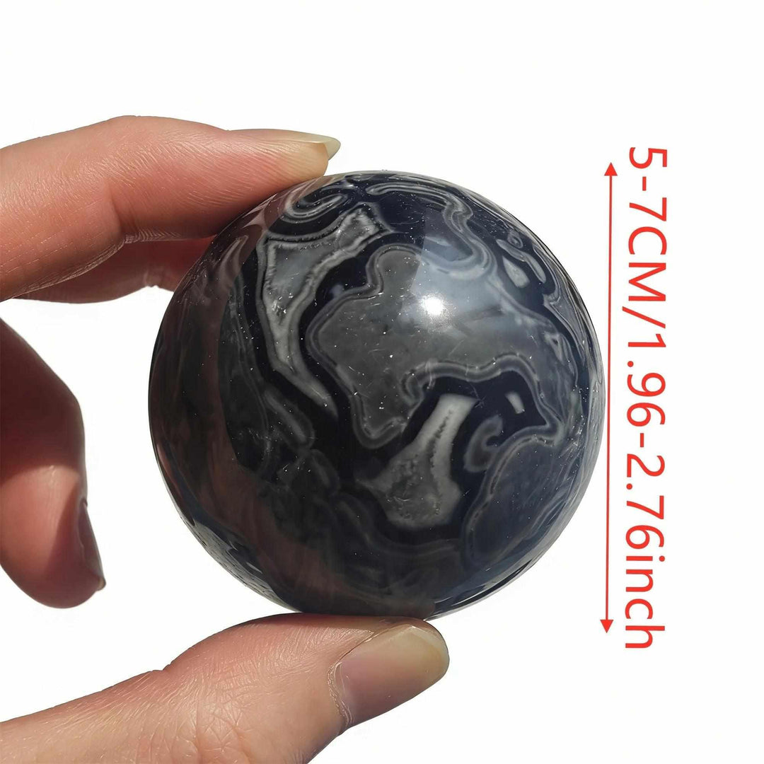 Polished Picasso Jasper sphere with abstract black and gray lines, 50-70mm, for grounded creativity and chakra healing.