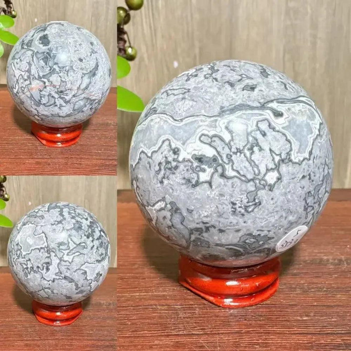Crystal Destiny Picasso Jasper sphere with abstract gray, black, and white patterns on a red stand.
