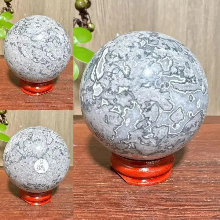 Crystal Destiny Picasso Jasper sphere, gray, black, brown, cream abstract patterns, on a red stand.