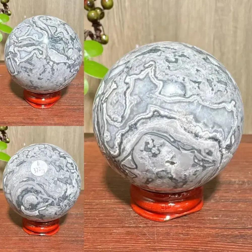 Crystal Destiny Picasso Jasper sphere, gray, black, and white abstract patterns, on a red stand.