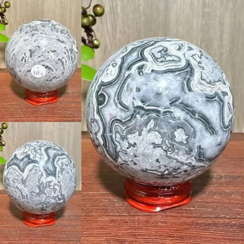 Picasso Jasper sphere from Crystal Destiny, featuring abstract gray, black, brown, and cream patterns on a red stand.