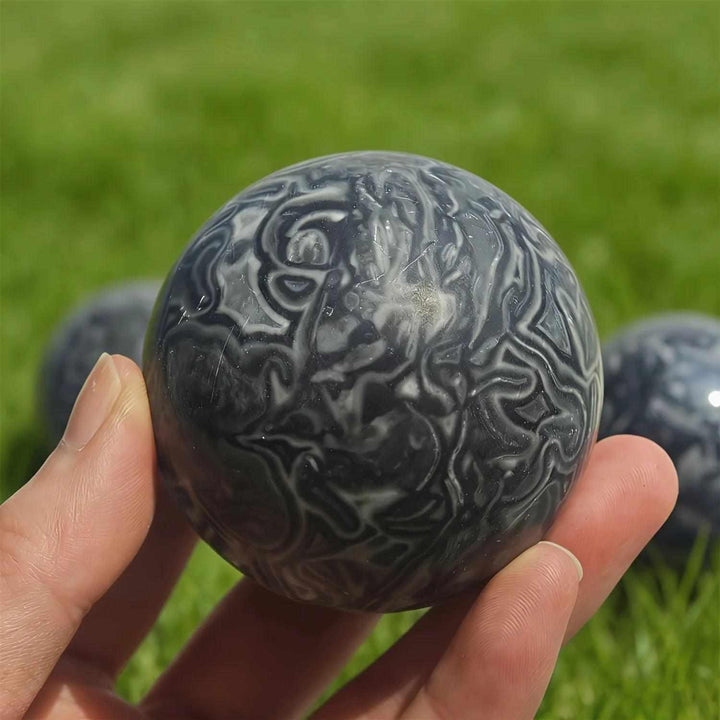 Polished Picasso Jasper sphere featuring abstract black and gray lines for grounded creativity and chakra balance.