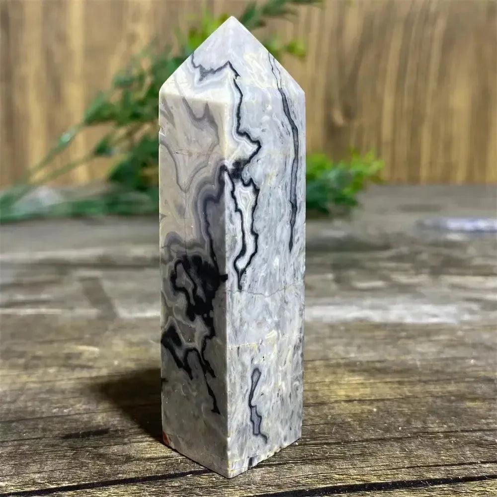 Picasso Stone Crystal Tower with bold black brushstrokes on warm cream, grounding Root Chakra stone.