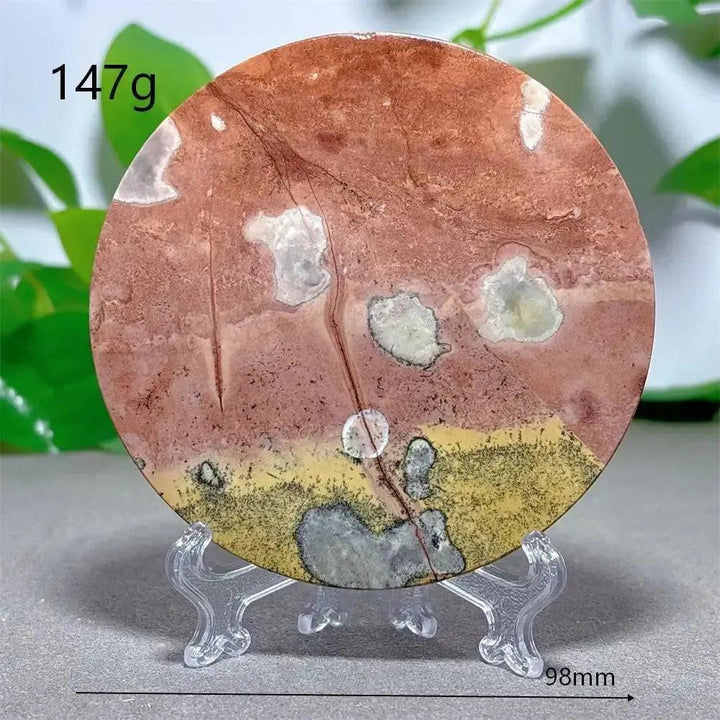 Crystal Destiny's round Picture Jasper slice with earthy red, cream, and ochre landscape patterns on a clear stand.