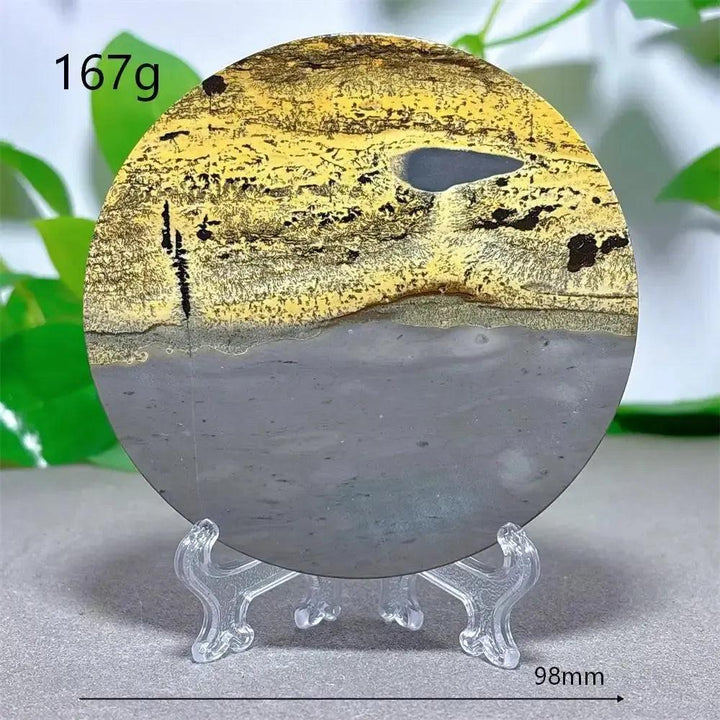 Round Picture Jasper crystal slice from Crystal Destiny, featuring earthy yellow, gray, and brown landscape patterns on a clear stand.