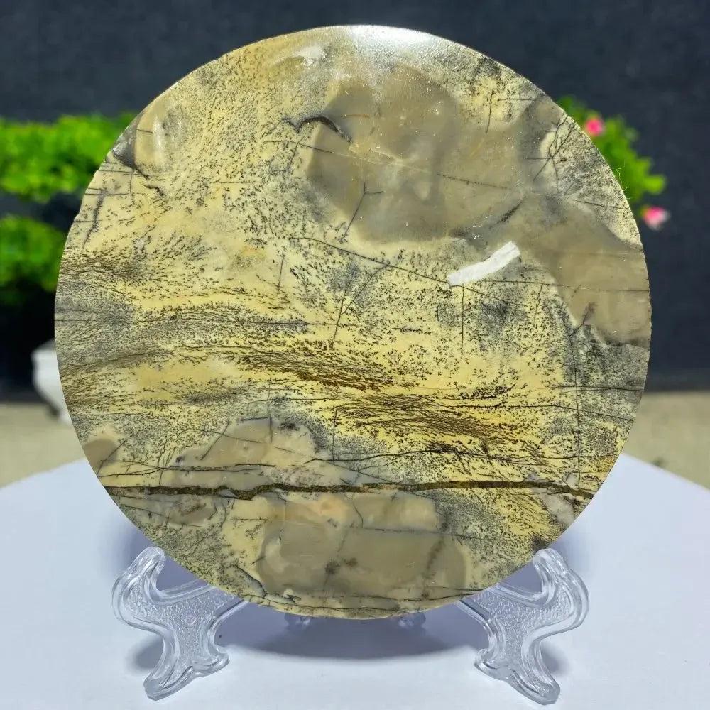Crystal Destiny's Picture Jasper slab, a round, polished stone with natural landscape patterns in earthy tones.