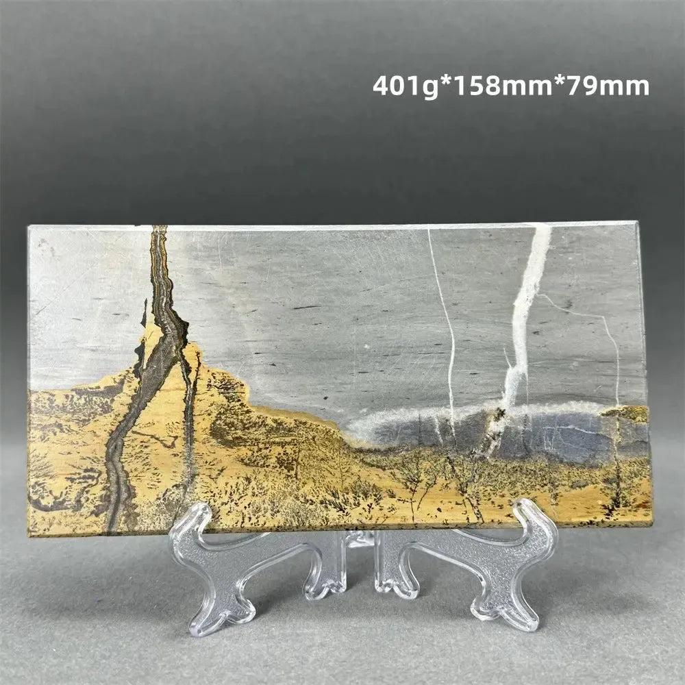 Polished Picture Jasper slice with natural landscape patterns in grey, gold, and brown, on a clear stand from Crystal Destiny.