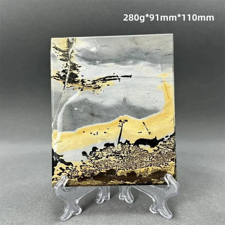 Polished Picture Jasper slice with natural landscape patterns in grey, gold, and black, on a clear stand from Crystal Destiny.