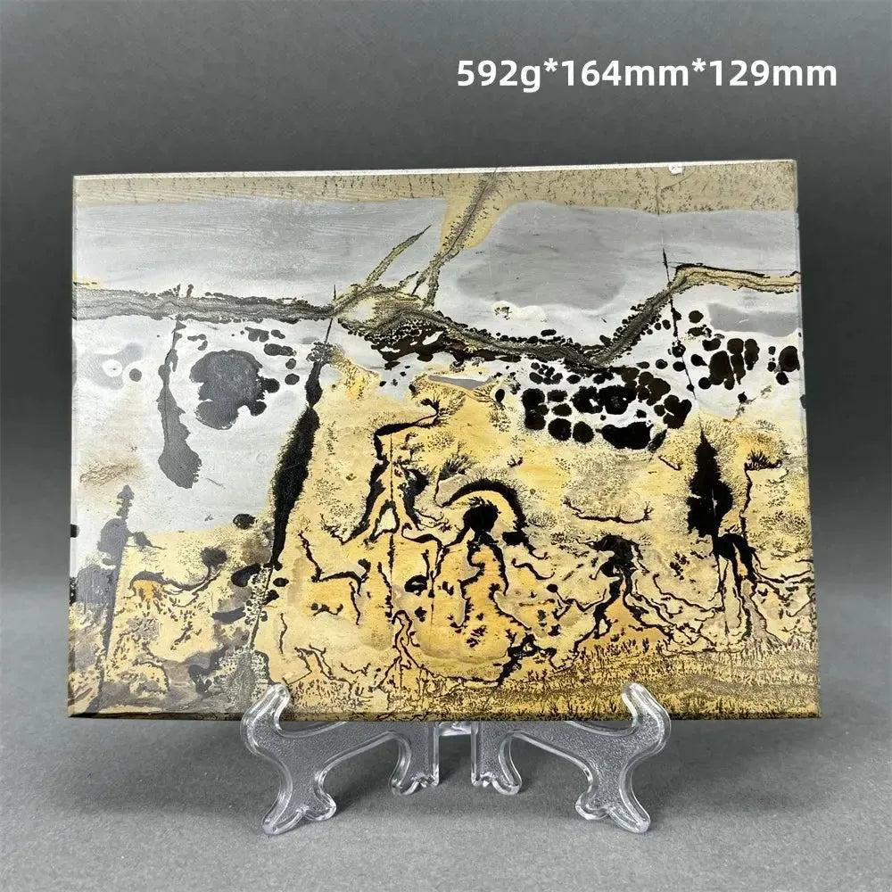 Polished Picture Jasper slice with unique landscape patterns in ochre, brown, and grey on a clear stand from Crystal Destiny.