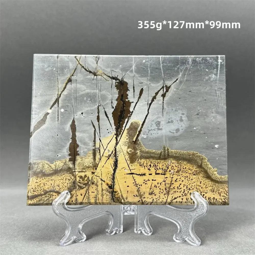 Polished Picture Jasper slice with unique landscape patterns in grey, gold, and brown, displayed on a clear stand from Crystal Destiny.