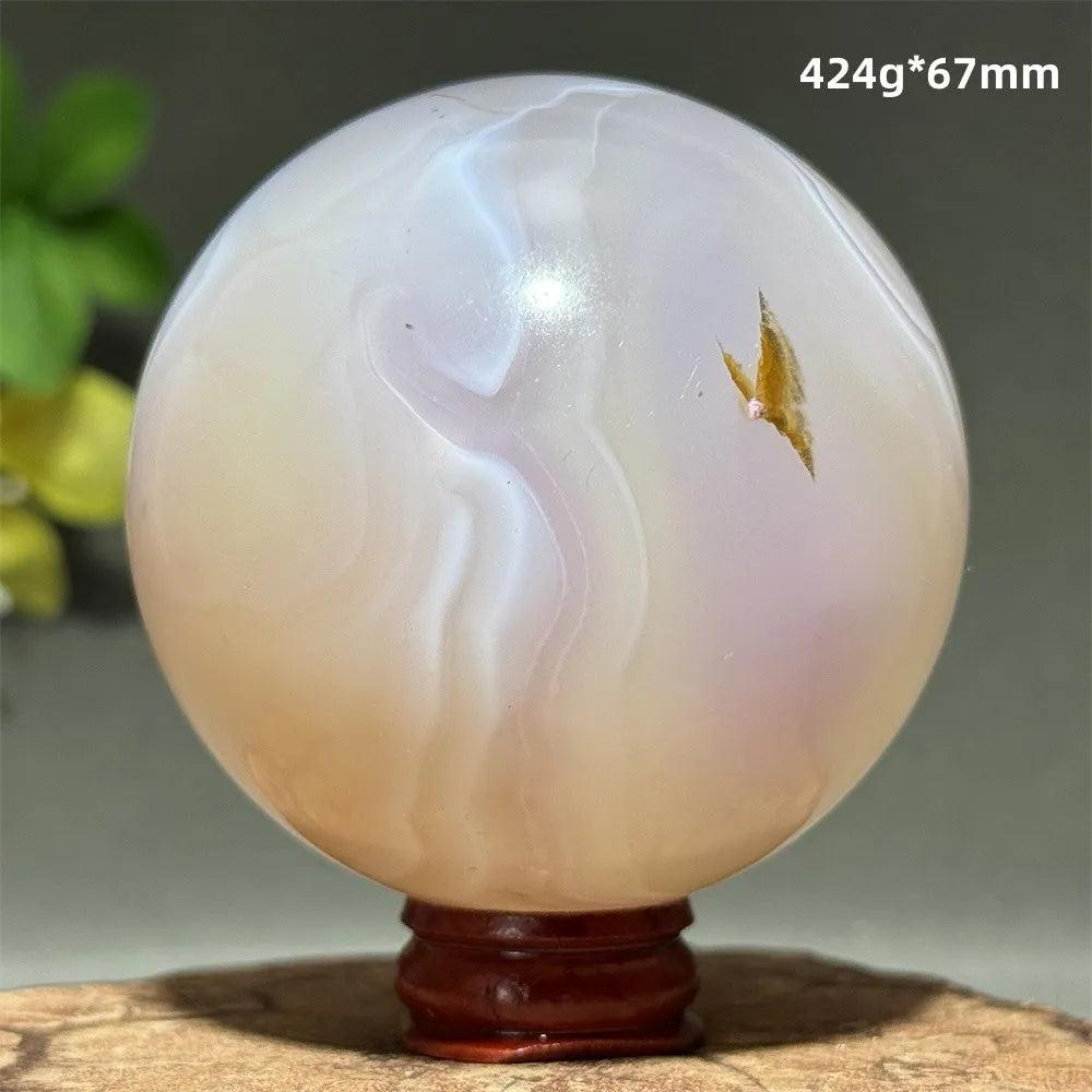 Polished 67mm Pink Agate crystal sphere featuring soft blush banding for Heart Chakra healing and grounding energy.