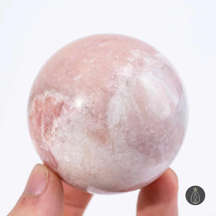 Polished pink opal sphere in blush and bubblegum tones, a 50-70mm crystal for heart chakra healing and emotional calm.