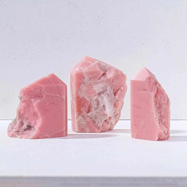 Three bubblegum pink opal towers with natural, irregular outlines for heart-centered healing and home decor.