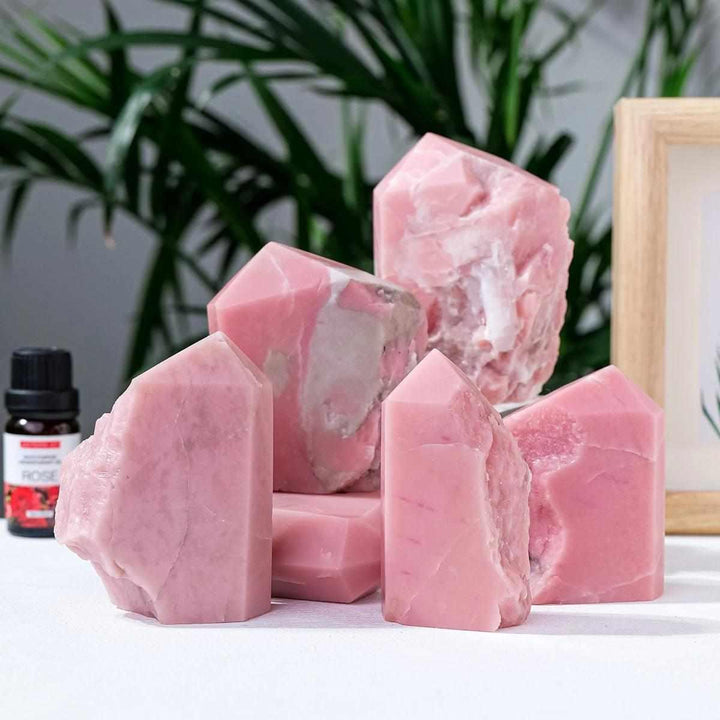 Polished bubblegum pink opal towers for heart chakra healing, featuring natural stone textures and unique crystal points.