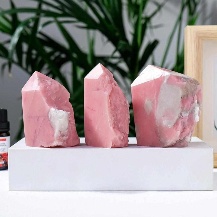 Three polished bubblegum pink opal towers with natural textures for heart chakra healing and calm home decor.