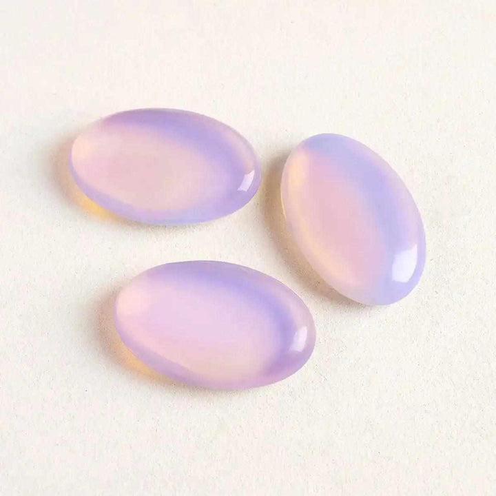 Three smooth, milky pink opalite palm stones with a glassy glow, perfect for Heart chakra meditation and self-love.
