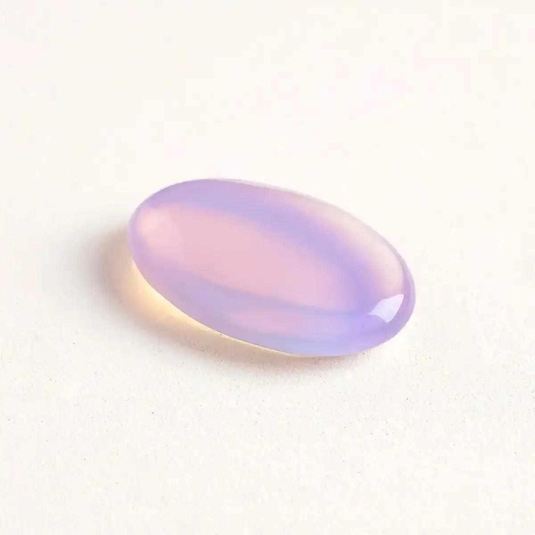 Smooth, milky pink opalite palm stone with a glassy, glowing finish for Heart chakra healing and calm meditation.