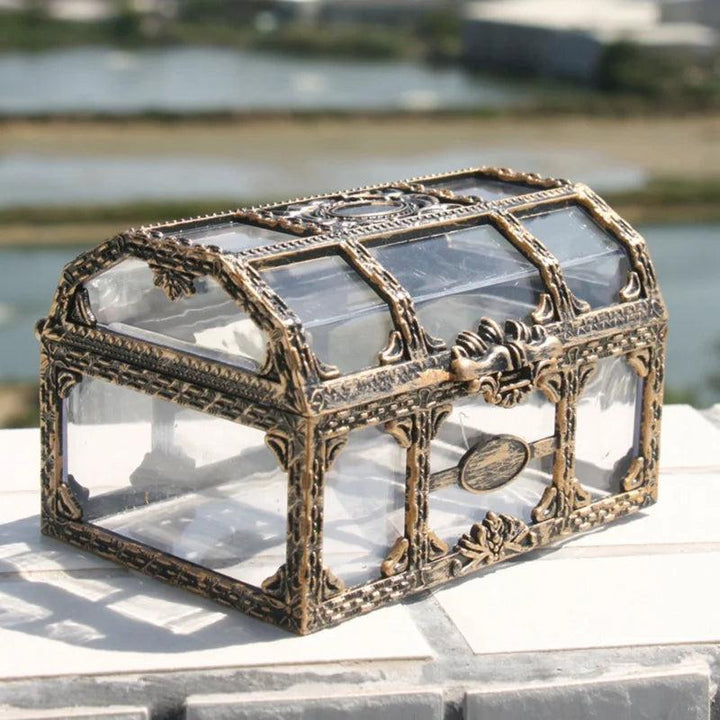 Clear plastic pirate treasure box with ornate gold detailing, perfect for storing and displaying your favorite crystals.