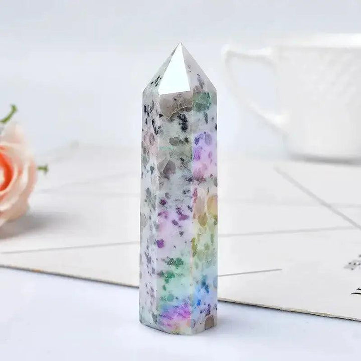 Polished natural crystal tower, a unique speckled stone with vibrant rainbow hues, perfect for energy work and decor.