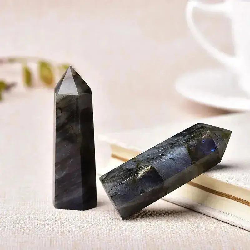 Two polished labradorite crystal towers, one upright and one horizontal, showcasing their unique dark hues and iridescent flashes.