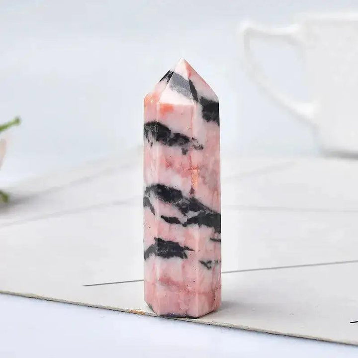 Polished pink Rhodonite crystal tower with black veins, ideal for chakra balancing and sacred spaces.