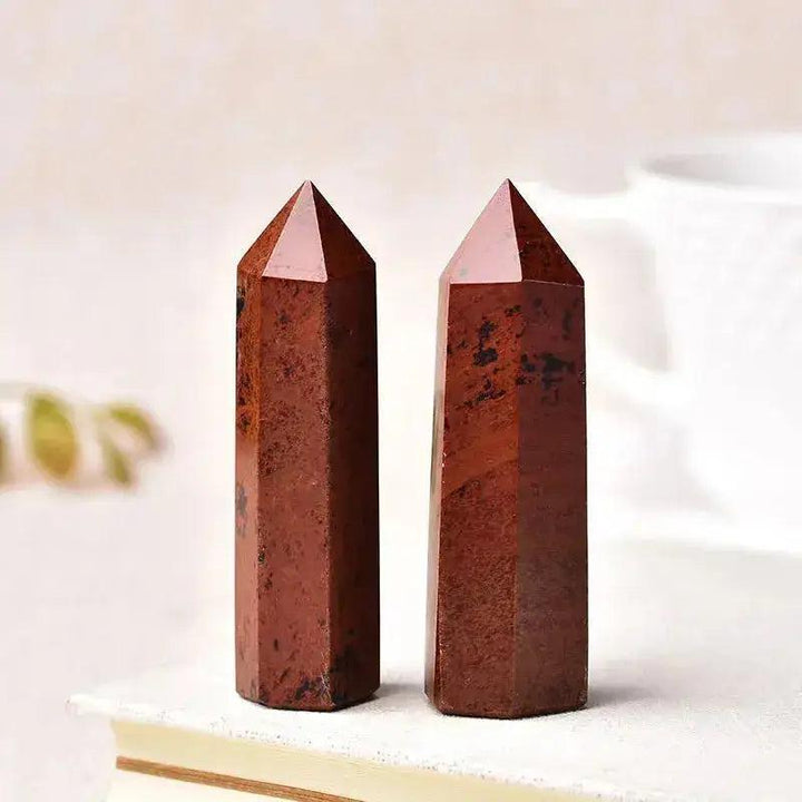 Two polished red crystal towers, showcasing unique patterns, perfect for energy work and home décor.