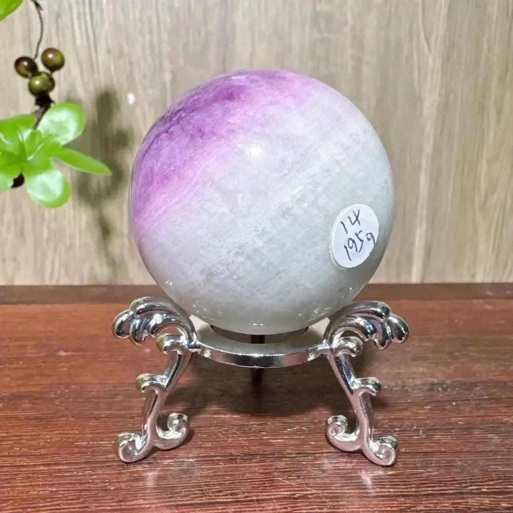 Polished purple fluorite crystal sphere on a silver stand, featuring lavender to violet hues for third eye chakra clarity.