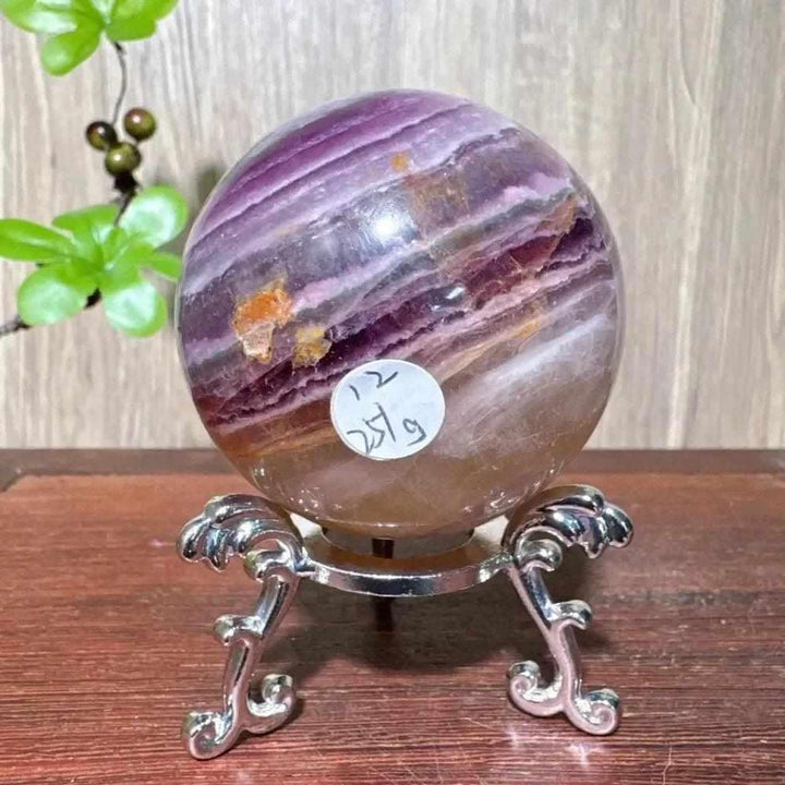 Polished purple fluorite crystal sphere with deep violet banding, perfect for Third Eye chakra clarity and energy healing.