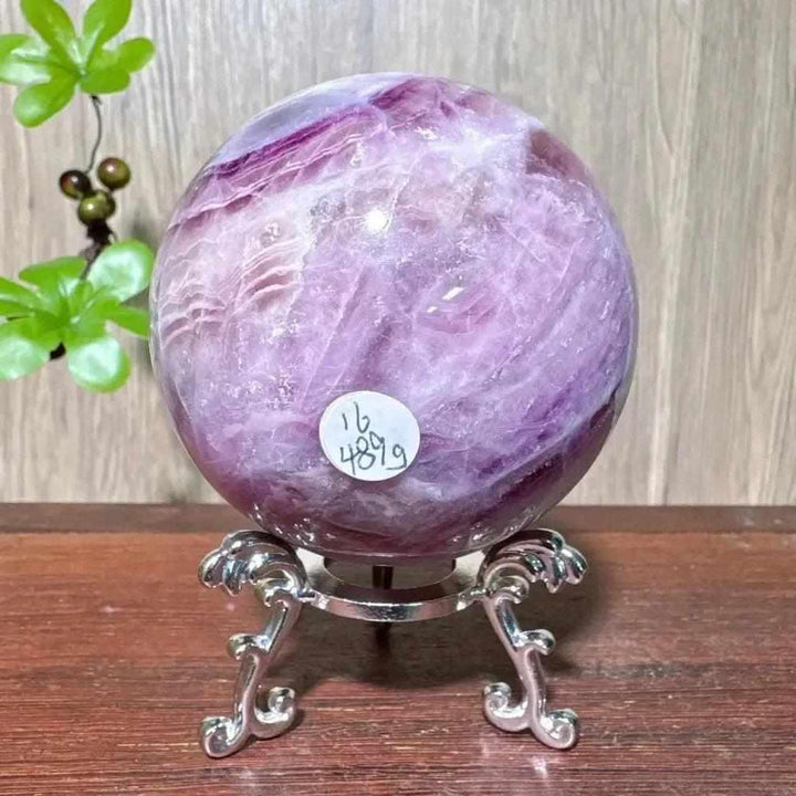 Polished purple fluorite crystal sphere with silky violet hues, perfect for third eye chakra clarity and energy healing.