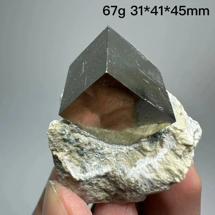 Metallic gold Pyrite Cube Crystal Specimen from Crystal Destiny, naturally formed with sharp edges on a rock base.